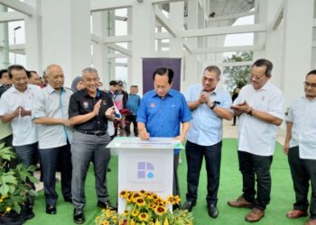 AHMAD MASLAN menandatangani plak semasa merasmikan Tangki Air Baharu Benut 4 di Benut, Pontian.