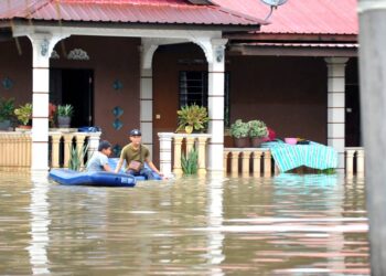 DUA penduduk bermain air banjir yang melanda Kampung Parit Warijo, Sri Medan, Batu Pahat.