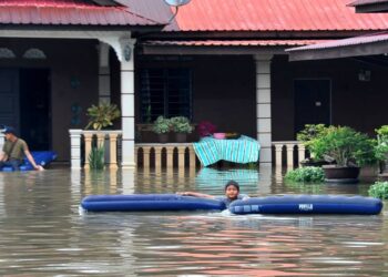 SEORANG kanak-kanak bermain air banjir yang melanda Kampung Parit Warijo, Sri Medan, Batu Pahat.