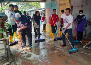 MANGSA dan pasukan sukarelawan bergotong-royong membersihkan rumah penduduk yang dilanda banjir di Kampung Bukit Raja, Kota Tinggi.