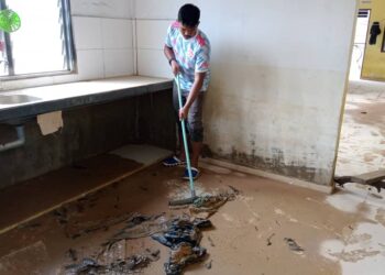 SEORANG penduduk membersihkan rumahnya yang berlumpur akibat dimasuki banjir di Kampung Seberang Batu Badak, Segamat.