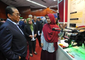 MOHAMED KHALED NORDIN (kiri) mendengar penerangan tentang dron ketika melawat pameran penyelidikan sempena lawatan ke UTM, Skudai, Johor Bahru.