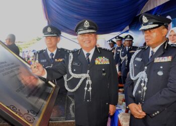 ABD. JALIL HASSAN menandatangani plak sambil diperhatikan oleh Kamarul Zaman (kanan) pada Majlis Perasmian Balai Polis Kelapa Sawit, Kulai.