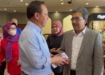 HASNI MOHAMMAD (kiri) berbual dengan Johari selepas menyerahkan borang pencalonan untuk bertanding jawatan Naib Presiden UMNO di PWTC, Kuala Lumpur.
