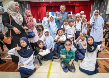 SALAHUDDIN AYUB (tengah) bergambar bersama-sama dengan penerima bantuan Program Kembali Ke Sekolah Parlimen Pulai di Johor Bahru.