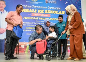 SALAHUDDIN AYUB (dua dari kanan) menyampaikan sumbangan bantuan persekolahan pada Program Kembali Ke Sekolah Parlimen Pulai, Johor Bahru.