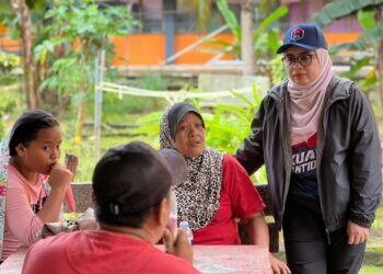 NORLIZA NOH (kiri) bertanya khabar kepada mangsa banjir di PPS SK Laksamana, Kota Tinggi.