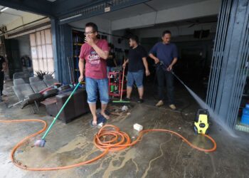 HAIRUL HELME ABD. RAHMAN (kanan) membersihkan bengkelnya yang terletak di Jalan Kota Kecil 1, Kota Tinggi.