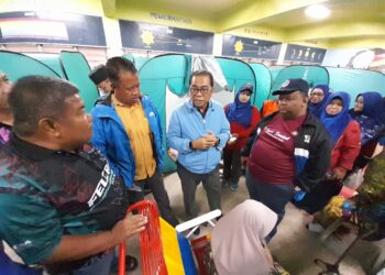 MOHAMED KHALED NORDIN (tengah) beramah mesra dengan mangsa banjir ketika melawat PPS di Sekolah Kebangsaan (SK) Mawai, Kota Tinggi.