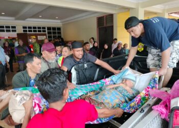 ANGGOTA pasukan Pemuda Muafakat Asyakirin membawa Rubiah Abdullah, 92, dari Kampung Parit Tengah Mukim Tujuh yang uzur untuk dibawa ke PPS Dewan Orang Ramai Parit Yaani, Batu Pahat.
