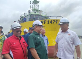 MOHAMAD Sabu (kanan) memperkatakan sesuatu kepada  Azman Ibrahim (tengah) dan Aminuddin Mat Yusof (kiri) selepas meninjau kapal yang dibina daripada besi pada lawatan di MSET Shipbuilding, Pulau Duyung, Kuala Terengganu, semalam. - UTUSAN/PUQTRA HAIRRY ROSLI