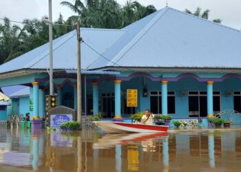 SEORANG penduduk, Saiful Mohamad menaiki bot di hadapan sebuah masjid yang dilanda banjir di Kampung Temehel, Yong Peng, Batu Pahat.