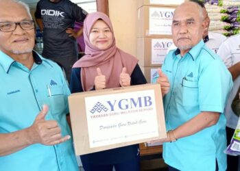 AMINUDIN ADAM (kiri) menyerahkan sumbangan YGMB sambil disaksikan   Menteri Pendidikan, Fahdlina Sidek untuk disampaikan kepada mangsa banjir di PPS SK Seri Bali, Chaah, Segamat.