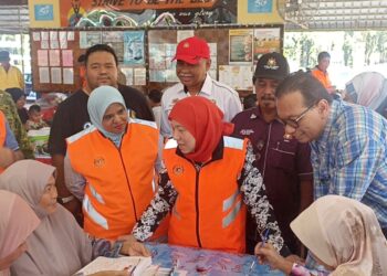 NANCY  SHUKRI (dua dari kanan) bertemu dengan petugas JKM di PPS SK Kota Dalam, Batu Pahat.