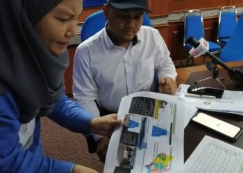 MOHAMAD FAZLI MOHAMAD SALLEH berbincang dengan Jurutera JPS Daerah, Nurliza Zakari pada Mesyuarat Task Force Banjir Negeri Johor di Pejabat JKR Daerah Muar.
