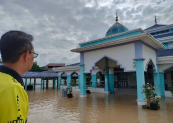 MOHD. FARED MOHD. KHALID meninjau keadaan Masjid Jamek Pekan Sri Gading yang dinaiki air sejak awal pagi tadi.