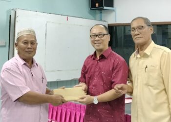 MOHD. NOR AZMI MD. ANUAR (tengah) disaksikan oleh Mustakim Jalil (kanan) menyampaikan cenderamata kepada ahli persatuan  sempena Mesyuarat Agung Tahunan Persatuan Pemandu Teksi Daerah Kluang di Kluang.