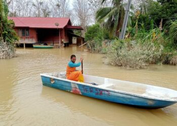 SEORANG penduduk Mohd. Tahar Md. Der mendayung sampan melihat keadaan rumah di Kampung Seberang Batu Badak, Segamat.