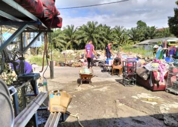 PENDUDUK membawa keluar barang dan perkakas rumah yang ditenggelami air untuk dibersihkan dan dibuang di Kampung Jawa, Chaah, Segamat.