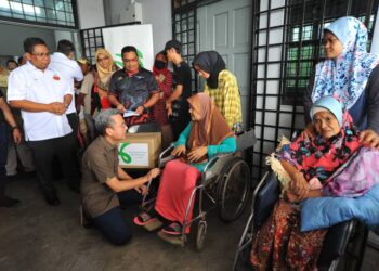 FAHMI FADZIL menyampaikan sumbangan semasa menyantuni mangsa banjir di Dewan Raya Kampung Sungai Tiram, Ulu Tiram, Johor Bahru.