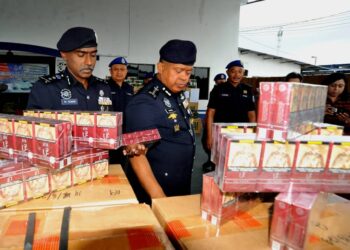 KAMARUL ZAMAN MAMAT melihat sebahagian rampasan pelbagai jenis rokok berjumlah RM1.7 juta di Pejabat Pasukan Polis Marin Wilayah Dua, Johor Bahru.