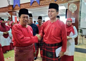 AHMAD MASLAN (kiri) berjabat tangan dengan Hasni Mohammad  semasa menghadiri Persidangan Perwakilan UMNO Bahagian Pontian di Dewan Jubli Intan Sultan Ibrahim, Pontian.