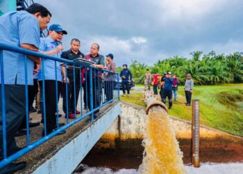 ONN HAFIZ GHAZI (dua dari kiri) meluangkan masa meninjau operasi pengepaman keluar air di kawasan banjir termenung di sekitar Batu Pahat.