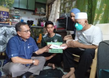 ZAINAL KAMARDIN (kanan) menerima sumbangan wang tunai dan barangan keperluan daripada Zaid Zain di kediamannya di Flat Sagu 34, Taman Daya, Johor Bahru.