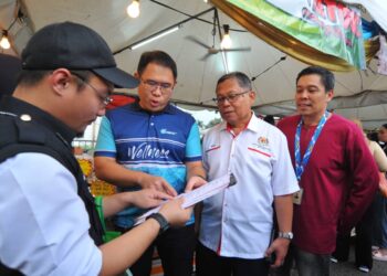 LING TIAN SOON (dua dari kiri) dan Dr. Aman Rabu melihat notis kompaun yang dikenakan  terhadap peniaga dalam operasi di Bazar Ramadan di Angsana Johor Bahru Mall.