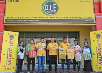 ZULKIFLI Harun (tengah) bersama pekerjanya menunjukkan produk minuman kesihatan yang dikeluarkan di Kilang GLE Centre Sdn Bhd,  di Bukit Kor, Marang, Terengganu, baru-baru ini.