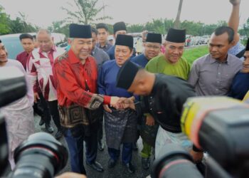 AHMAD ZAHID HAMIDI (tengah) bersalaman dengan orang ramai sambil diiringi Onn Hafiz dan Ahmad pada Rumah Terbuka Aidilfitri UMNO Bahagian Pontian dengan kerjasama Badan Perhubungan UMNO Johor di Kompleks Muafakat Benut, Pontian.