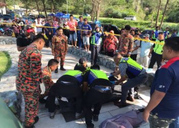 ANGGOTA bomba dan polis mengangkat dua beradik yang lemas ketika mandi-manda di Pantai Tanjung Buloh, Tanjung Sedili, Kota Tinggi.