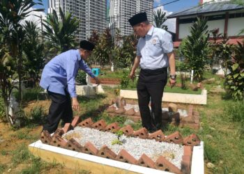 JAMALUDIN A. HAMID (kanan) menunjukkan salah sebuah kubur yang kehilangan batu nisan di Tanah Perkuburan Islam Taman Istimewa, Johor Bahru.