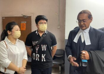 G.K. SRITHARAN (kanan) berbincang dengan Braden Yap (tengah) di pekarangan Mahkamah Sesyen, Johor Bahru.