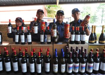 MISBAHUDIN PARMIN (dua dari kanan)  menunjukkan minuman keras yang dirampas hasil serbuan ke atas sebuah gudang di Gelang Patah pada sidang akhbar di Menara Kastam, Johor Bahru.