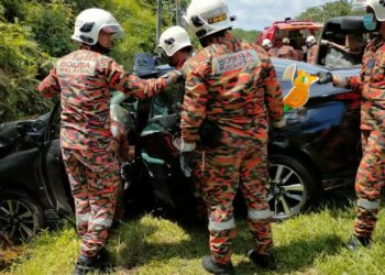 ANGGOTA bomba mengeluarkan mayat mangsa yang terlibat dalam kemalangan di Kilometer 68, Jalan Yong Peng-Kluang.