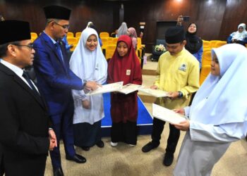 MOHD. FARED MOHD. KHALID (dua dari kiri) beramah mesra dengan empat pelajar cemerlang pada Majlis Pengumuman Keputusan Peperiksaan Darjah Khas Agama dan Sekolah Menengah Agama di Kompleks Islam Iskandar, Johor Bahru.