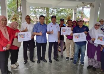 MOHD. JAFNI MD. SHUKOR (tengah) bergambar dengan beberapa penghuni selepas melawat flat awam di Kangkar Pulai, Johor Bahru.