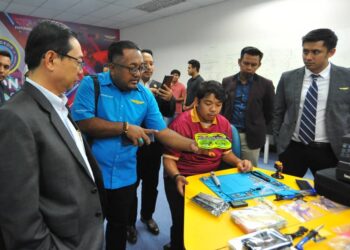 AHMAD FAUZI ISMAIL (kiri) diberi penerangan tentang pembuatan dron pada Majlis Pelancaran Pusat Kecemerlangan Satelit Makmal Aksadron dan menandatangani MoU antara UTM dengan Futurise Sdn. Bhd., di UTM Skudai, Johor Bahru.
