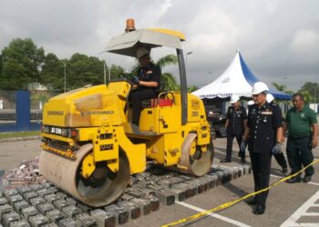 RAHMAT ARIFFIN memandu 'steamroller' melenyek mesin bitcoin pada Majlis Pelupusan Barang Kes di IPD Iskandar Puteri, Johor Bahru.