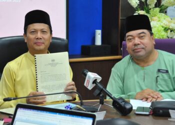 ANUAR SUKIRAN (kiri) menunjukkan keputusan penuh SPM 2022 di Pejabat Pendidikan Negeri Johor, Johor Bahru.