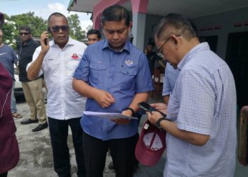 MOHD. HAFFIZ AHMAD (tengah) melihat pelan tembok pencegah banjir yang akan dibina bagi mengatasi isu banjir kilat di kawasan Iskandar Puteri.