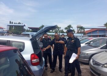 HANIF Yusabra Yusuf
(kanan) memeriksa kereta klon pada lelongan awam di JPJ Kelantan, Panji, Kelantan. - UTUSAN/ROSLIZA MOHAMED