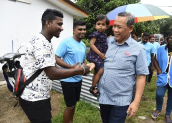 AMINUDDIN Harun beramah mesra bersama penduduk setempat di Ladang Sengkang, Pasir Panjang, Port Dickson.-UTUSAN/ZAKKINA WATI AHMAD TARMIZI.