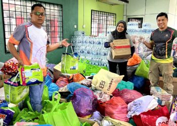 MOHD. Shahril Anuar (kanan) bersama sukarelawan menunjukkan barangan yang diterima mereka oleh masyarakat sekitar Seremban untuk dihantar ke mangsa banjir di negeri-negeri di Pantai Timur .-UTUSAN/ZAKKINA WATI AHMAD TARMIZI.