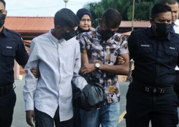 M. Hashagaan (tiga dari kanan) dan Kugananthan (dua dari kiri) didakwa di Mahkamah Majistret Port Dickson hari ini atas pertuduhan melakukan ugutan jenayah terhadap seorang peniaga Januari lalu.-UTUSAN/MOHD. SHAHJEHAN MAAMIN.