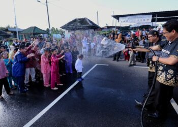 MOHAMAD Rafie Ab Malek menyiram air kepada kanak-kanak yang menyertai program berkhatan pada Program Berkhatan Percuma Untuk Keluarga Asnaf dan B40 di Masjid Dato' Klana Petra Sendeng dekat Ampangan, Seremban hari ini.-UTUSAN/MOHD. SHAHJEHAN MAAMIN.