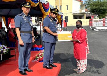 HAMDAN Ali (tengah) menyampaikan sumbangan kebajikan kepada salah seorang keluarga anggota bomba pada Majlis Perbarisan Tahunan Jabatan Bomba dan Penyelamat Malaysia (JBPM) Negeri Sembilan di Balai Bomba dan Penyelamat Seremban hari ini.- UTUSAN/ZAKKINA WATI AHMAD TARMIZI.