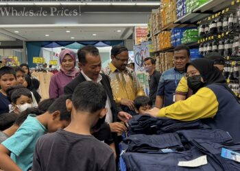 S. Veerapan (lima dari kanan) dan Muhammad Zahir (enam dari kanan) memilih pakaian sekolah untuk diberikan kepada kanak-kanak pada rogram Cintai Asnaf ‘Back To School’ di Seremban 2, Seremban hari ini.-UTUSAN/ZAKKINA WATI AHMAD TARMIZI.