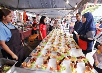 SITI Yusnita Mohamad Yusof (kanan) mengedarkan risalah kepada peniaga pada Majlis Pelancaran MYSaveFood Ramadan 2023 di Bazar Ramadan Stadium Tuanku Abdul Rahman, Paroi, Seremban hari ini.-UTUSAN/MOHD. SHAHJEHAN MAAMIN.